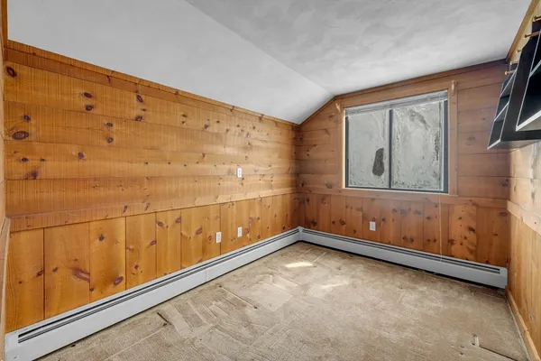 a view of empty room with wooden floor and window