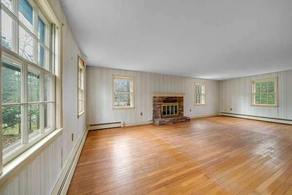 a view of empty room with fireplace and wooden floor