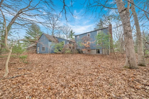 a view of a house with backyard and trees