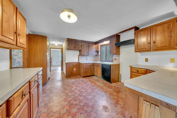 a kitchen that has a lot of cabinets and wooden floor