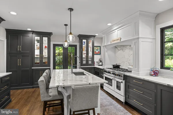 a kitchen with stainless steel appliances a stove a sink a dining table and chairs