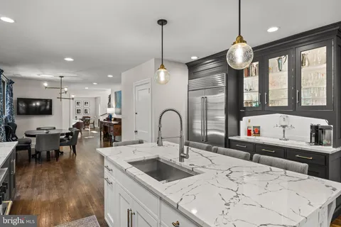 a kitchen with stainless steel appliances kitchen island granite countertop a stove a sink a oven and a dining table with wooden floor