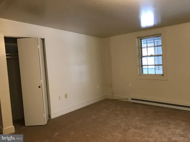 an empty room with windows and closet
