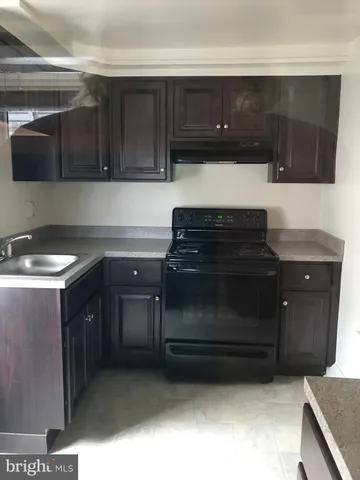 a kitchen with granite countertop a stove and a microwave