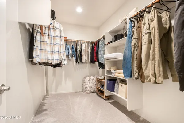 a view of walk in closet with clothes and shoes