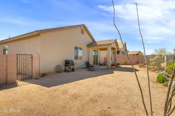 a backyard of a house with barbeque oven table and chairs
