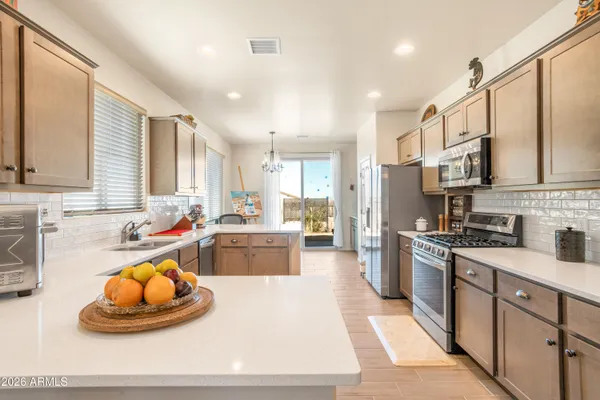 a large kitchen with stainless steel appliances lots of counter space and a sink