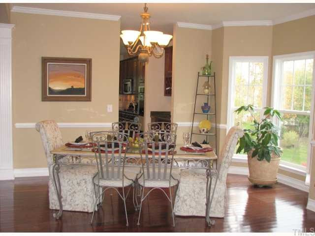 125 Locke Woods Road Raleigh, NC 27603 - Photo 5 of 12 The elegant dining room is open to the living room and features hardwood floors, crown molding, decorative columns, and a large bay window.