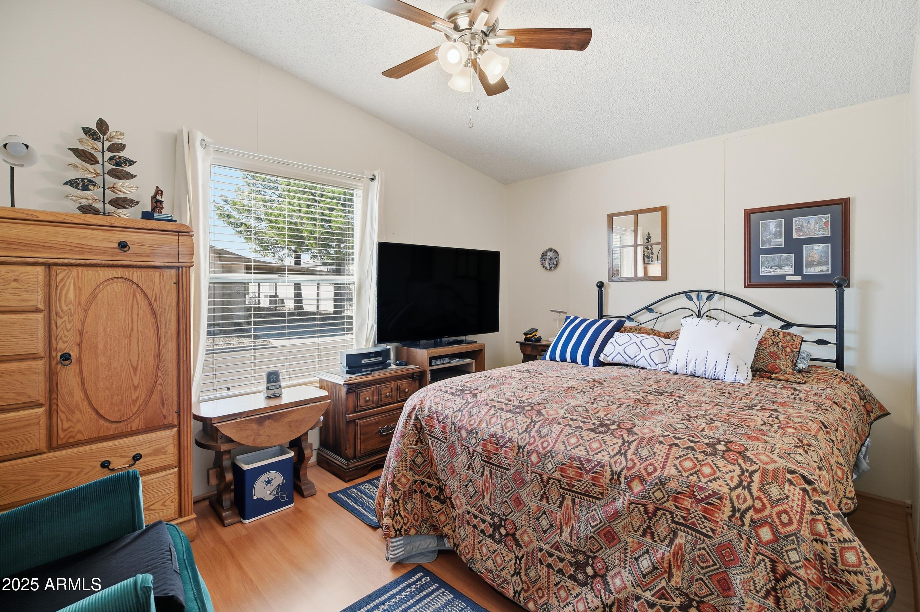2050 West State Rte 89A, Unit 92 Sedona, AZ 86336 - Photo 23 of 34 a bedroom with a bed a dresser and flat screen tv