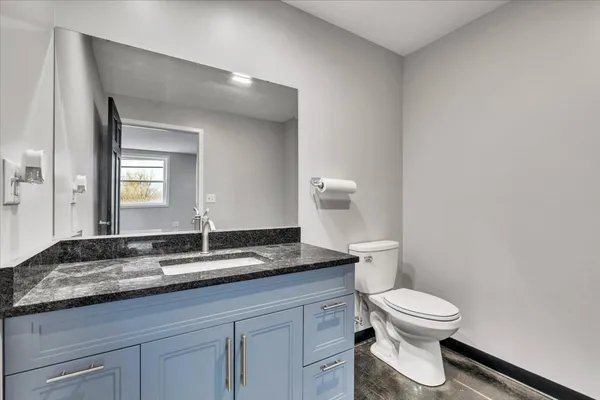 a modern kitchen with stainless steel appliances kitchen island granite countertop a refrigerator and a sink