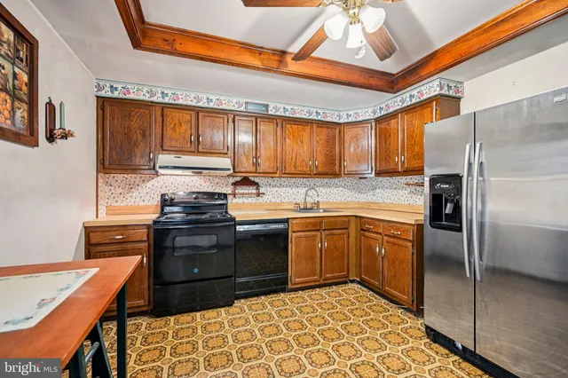 a kitchen with stainless steel appliances granite countertop a stove a sink and a refrigerator