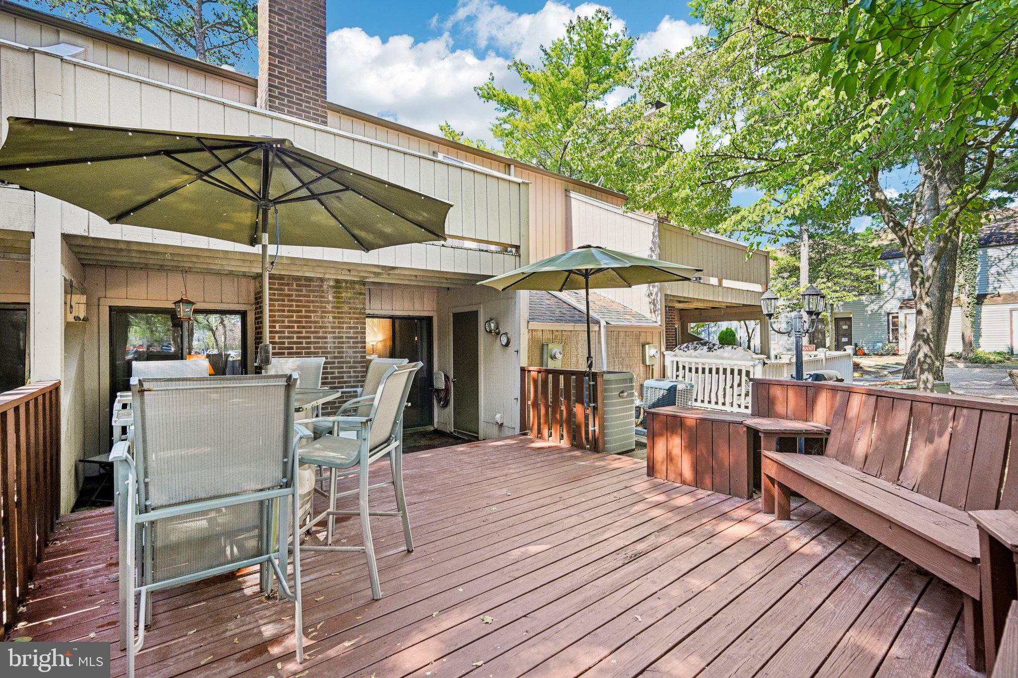 1502 Bromley Estate Pine Hill, NJ 08021 - Photo 30 of 36 a patio with wooden floor a yard a table and chairs