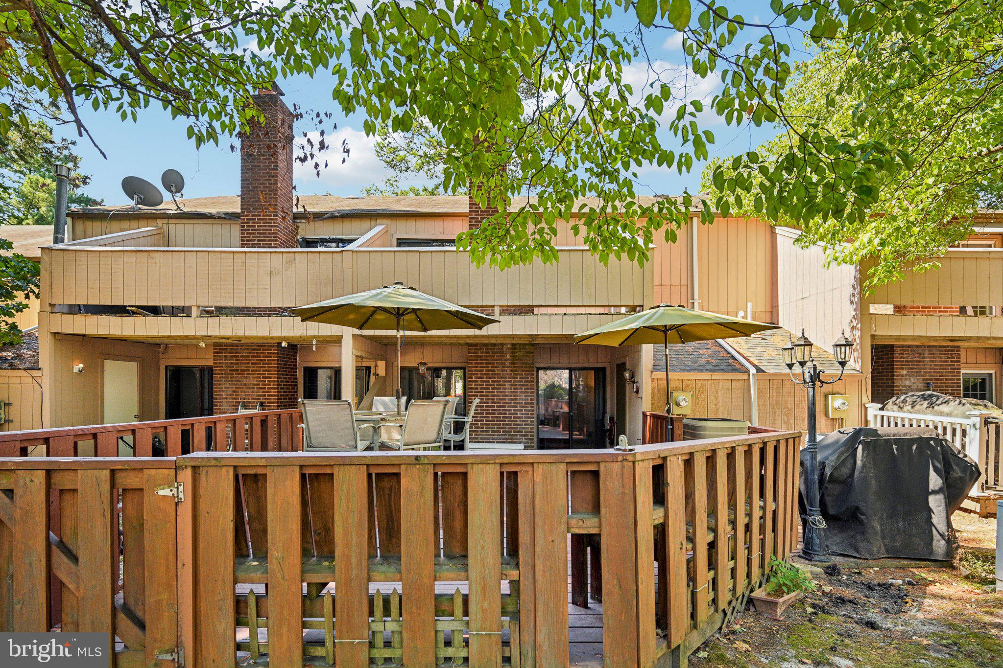 1502 Bromley Estate Pine Hill, NJ 08021 - Photo 32 of 36 a view of a white house with large trees and wooden fence