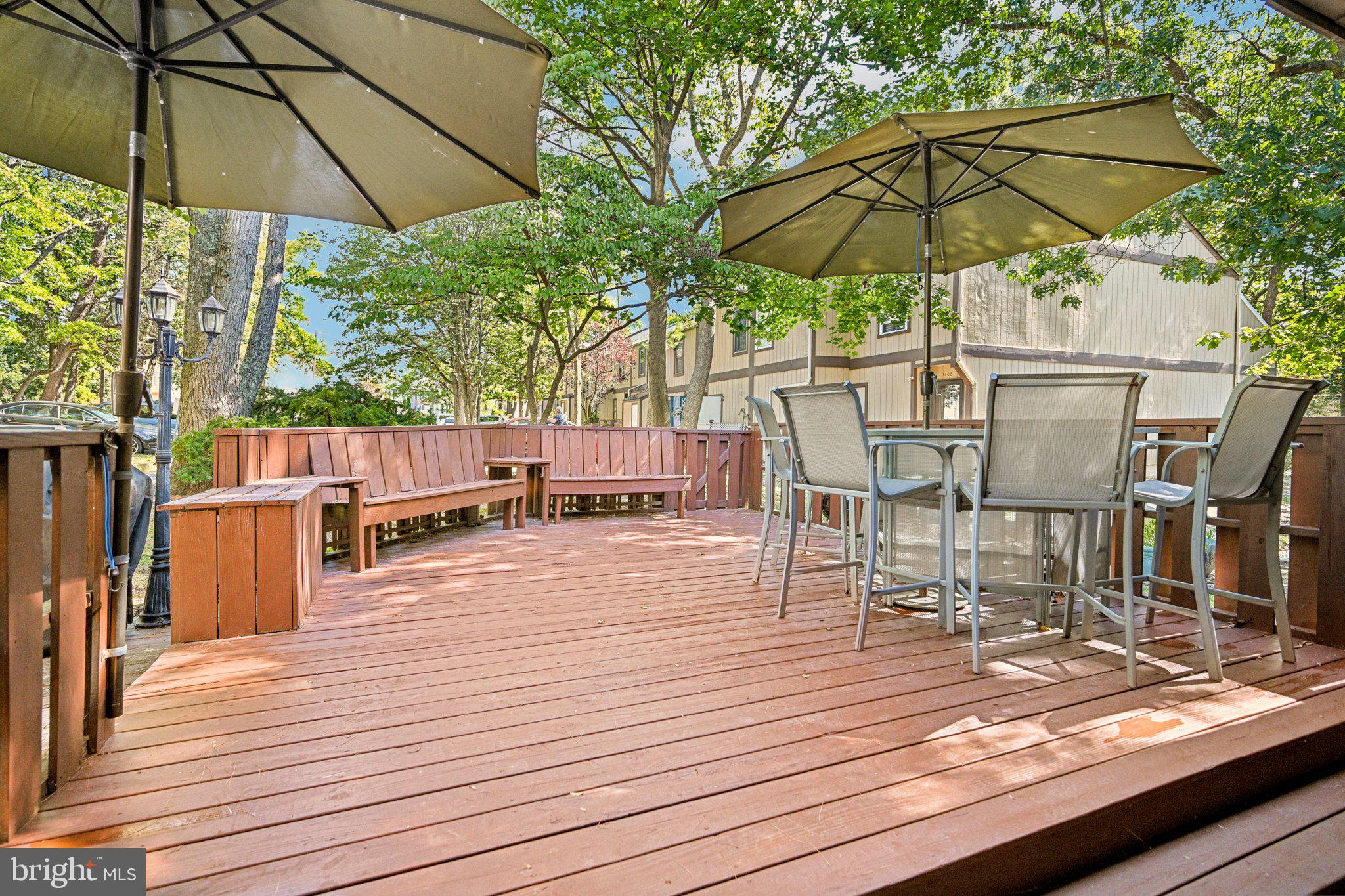1502 Bromley Estate Pine Hill, NJ 08021 - Photo 36 of 36 a view of a roof deck with table and chairs under an umbrella with wooden floor