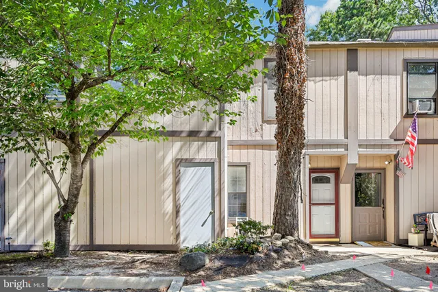 a view of a house with a tree next to a yard