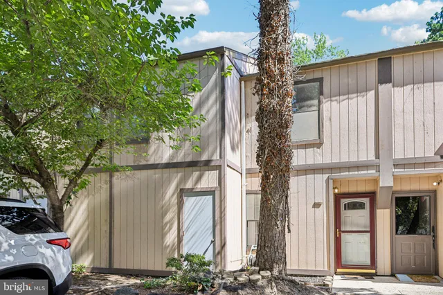 a front view of a house with a tree