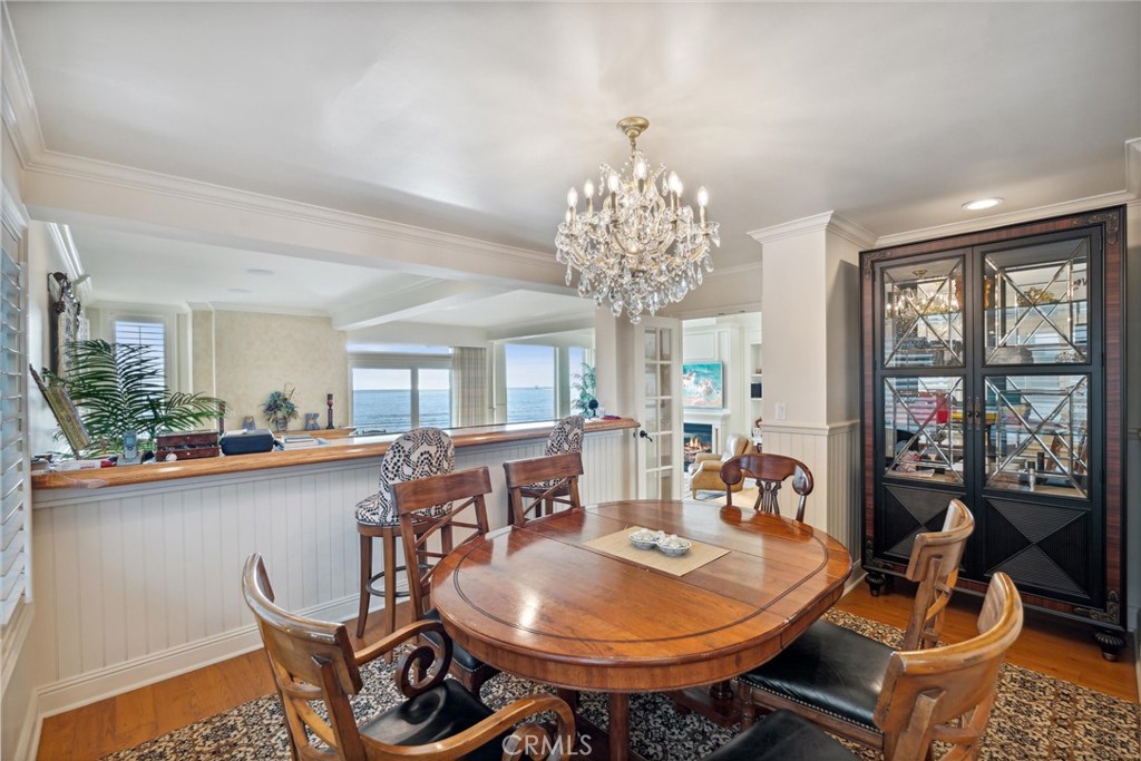 1008 West Oceanfront Newport Beach, CA 92661 - Photo 19 of 59 a dining room with furniture a chandelier and wooden floor