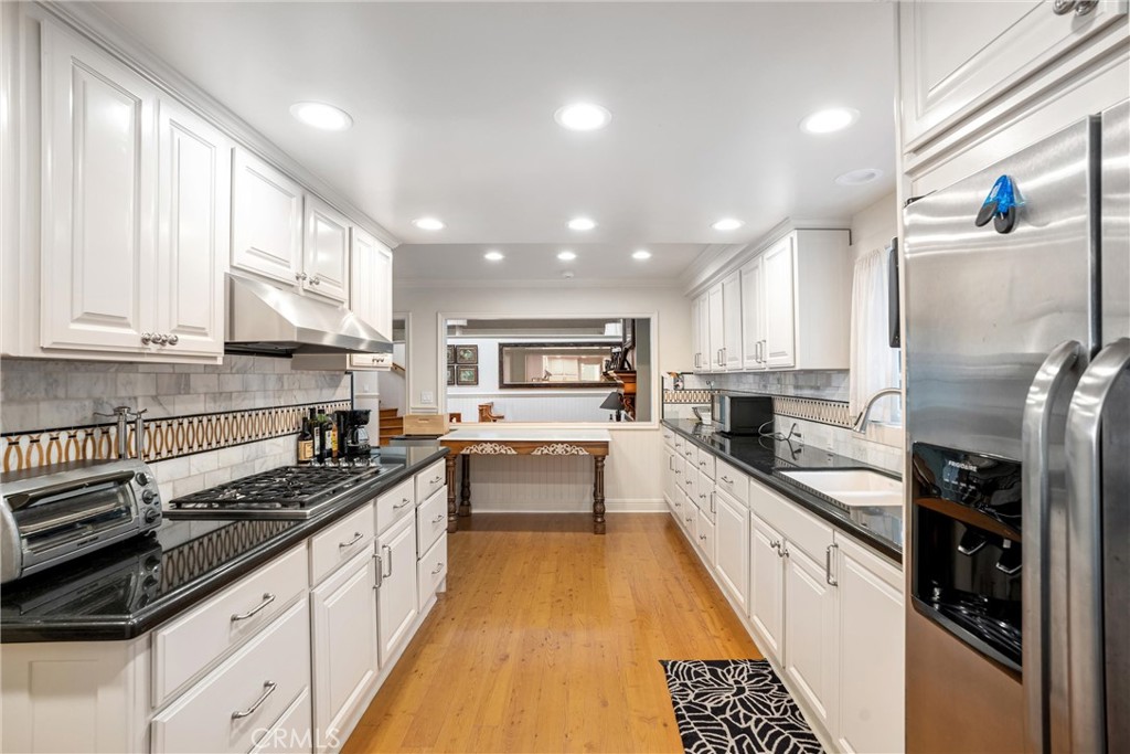 1008 West Oceanfront Newport Beach, CA 92661 - Photo 20 of 59 a large kitchen with stainless steel appliances granite countertop a sink and cabinets