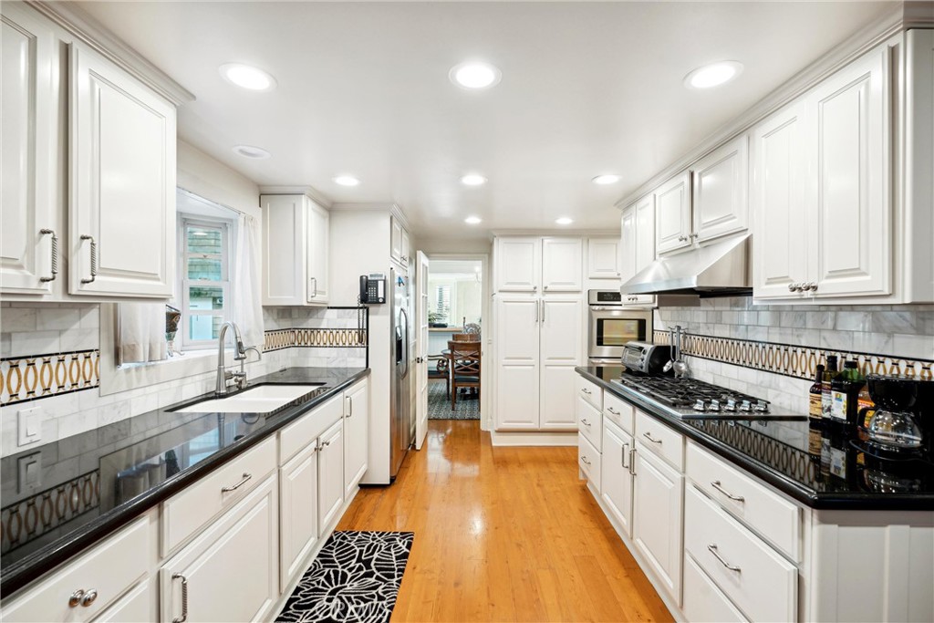 1008 West Oceanfront Newport Beach, CA 92661 - Photo 22 of 59 a kitchen with granite countertop a sink a counter space stainless steel appliances and cabinets