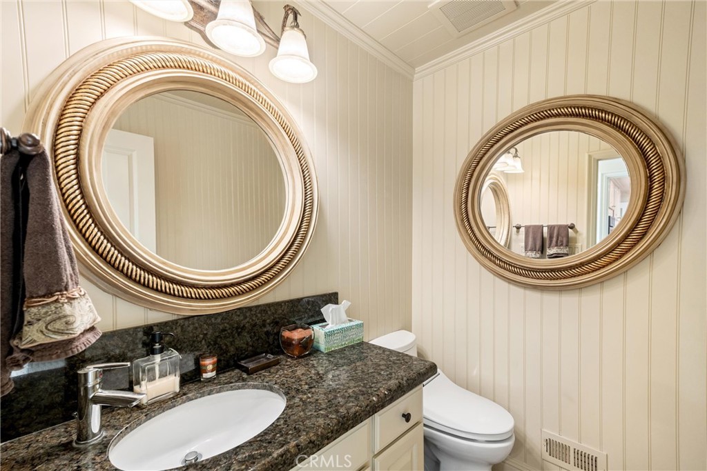 1008 West Oceanfront Newport Beach, CA 92661 - Photo 24 of 59 a bathroom with a granite countertop toilet a sink and a mirror