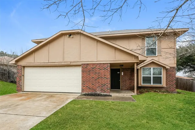 a front view of a house with a garden and yard