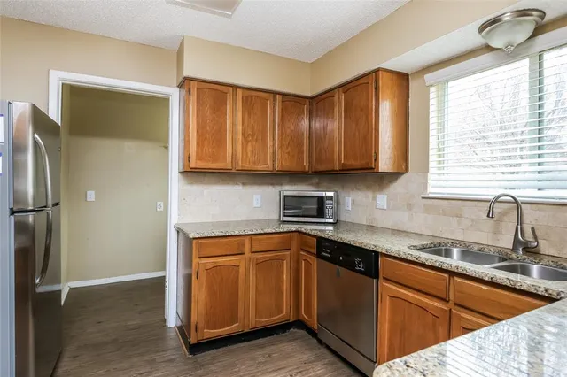 a kitchen with stainless steel appliances granite countertop a sink stove and refrigerator