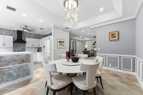 a view of a dining room with furniture a chandelier and wooden floor