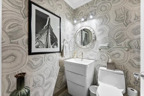 a bathroom with a toilet sink and mirror