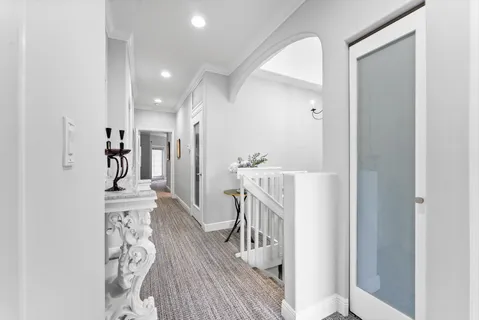 a view of a hallway with furniture and wooden floor