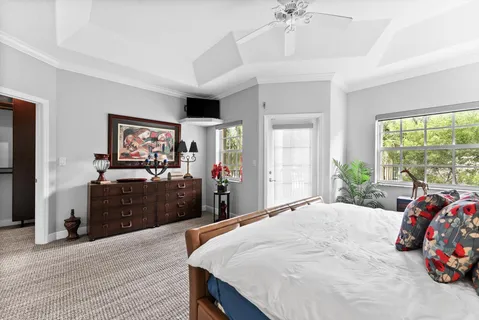 a bedroom with a bed and a flat tv screen on dresser