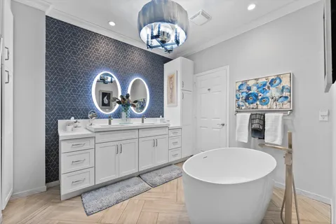 a spacious bathroom with a sink a large mirror and a bathtub