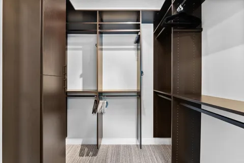 a view of walk in closet with empty racks