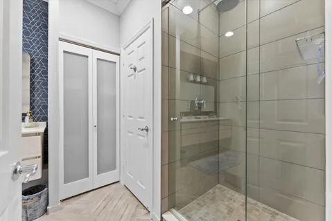 a bathroom with a shower and a sink a mirror