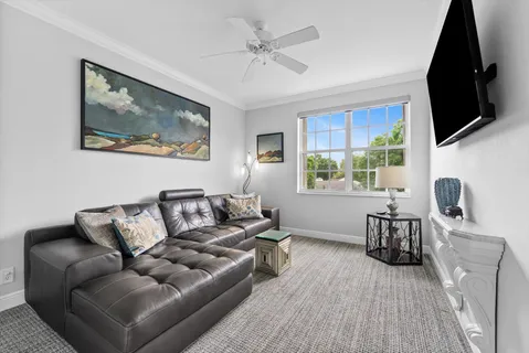 a living room with furniture a flat screen tv and a window