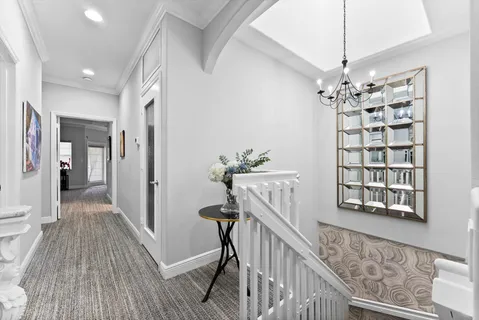 a view of a hallway with wooden floor and staircase