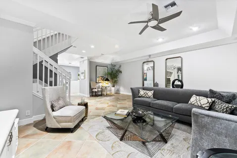 a living room with furniture and a ceiling fan