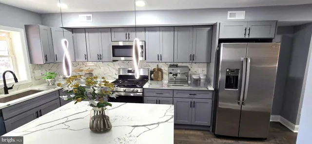 a kitchen with stainless steel appliances a refrigerator a sink a stove a microwave a counter top space and cabinets