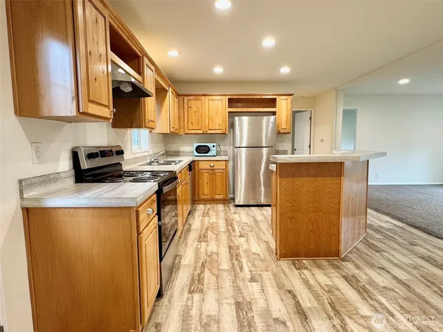 a kitchen with refrigerator and cabinets