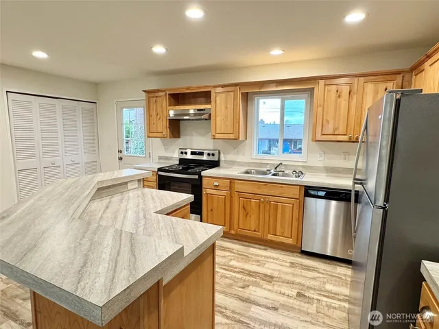 a kitchen with stainless steel appliances granite countertop a sink stove and refrigerator