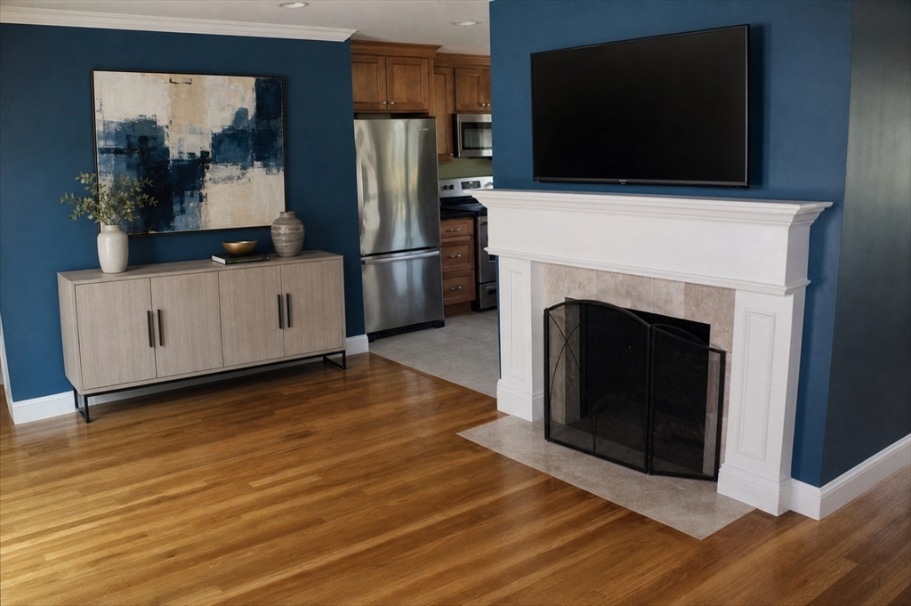 21 Whitcomb Drive Lancaster, MA 01523 - Photo 8 of 23 a living room with a fireplace and a flat screen tv