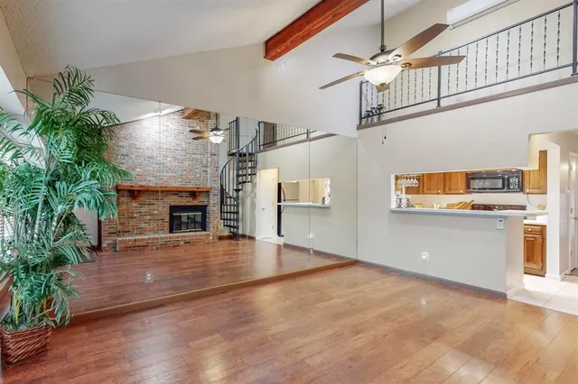a view of empty room with wooden floor and fireplace