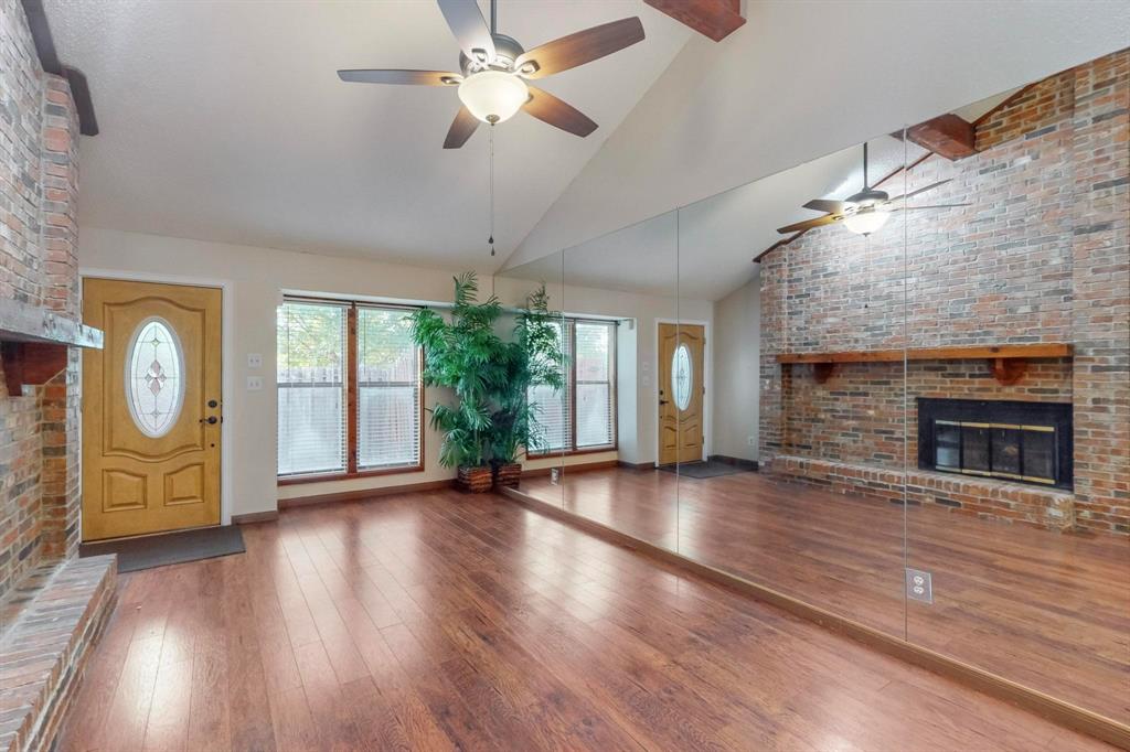 2569 Shady Ridge Drive Bedford, TX 76021 - Photo 9 of 38 a view of an empty room with wooden floor fireplace and a window