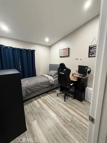 a bedroom with a bed and a computer on a table