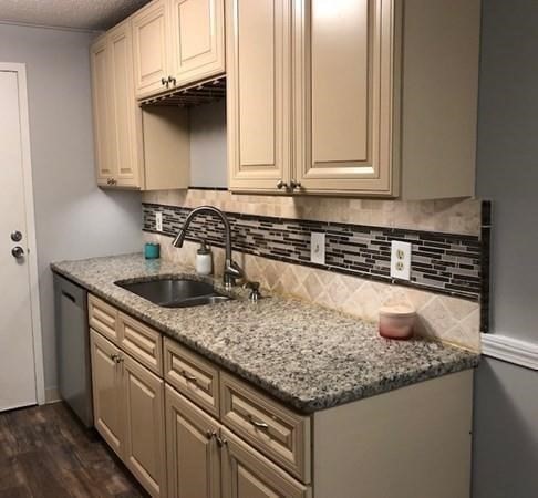 46 Silver Hill Lane, Unit 2 Natick, MA 01760 - Photo 3 of 23 a kitchen with granite countertop a sink and a white cabinets