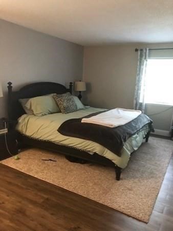 46 Silver Hill Lane, Unit 2 Natick, MA 01760 - Photo 6 of 23 a bedroom with a bed and wooden floor