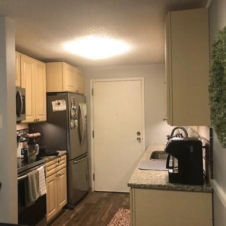 46 Silver Hill Lane, Unit 2 Natick, MA 01760 - Photo 7 of 23 a kitchen with stainless steel appliances granite countertop a sink a stove and refrigerator