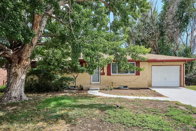 a view of the house with yard and trees