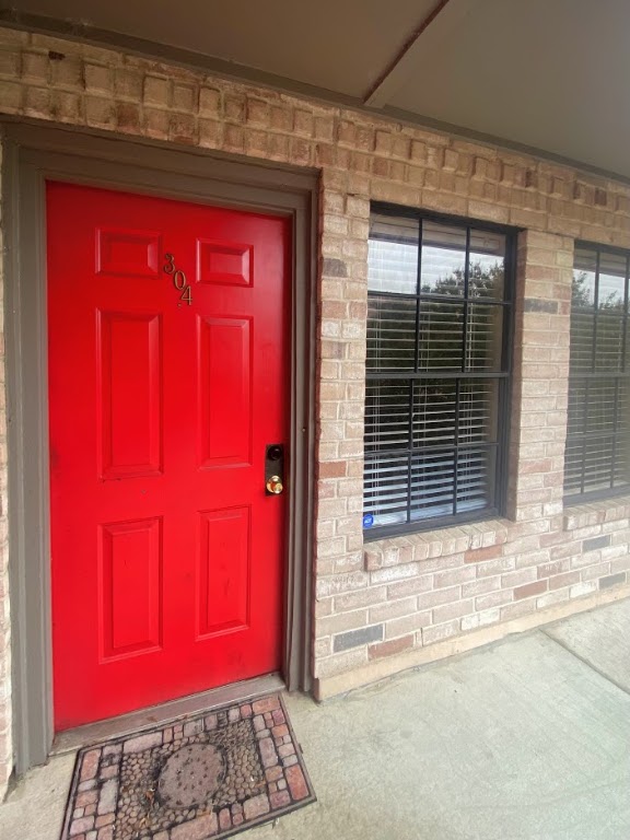 Doorway to property with brick siding