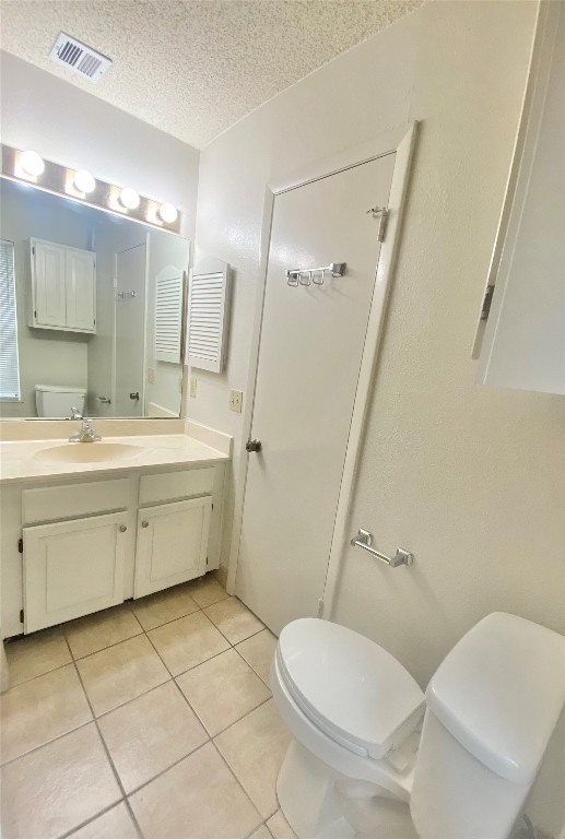2216 San Gabriel Street, Unit 304 Austin, TX 78705 - Photo 11 of 24 Bathroom with tile patterned floors, a textured ceiling, visible vents, and toilet