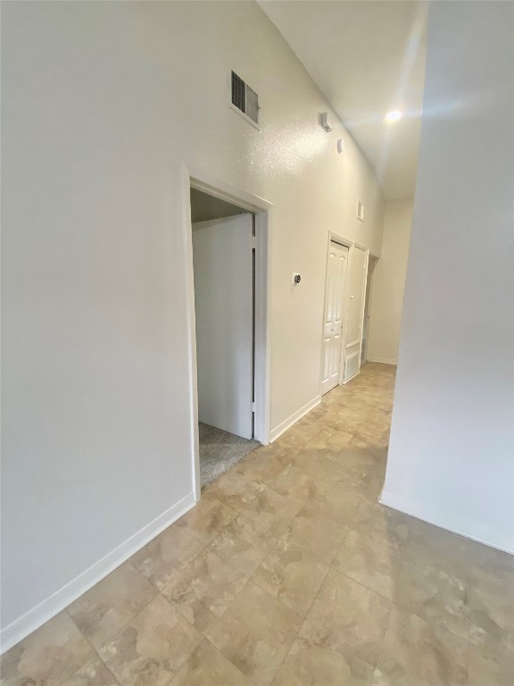 2216 San Gabriel Street, Unit 304 Austin, TX 78705 - Photo 5 of 24 Corridor featuring a towering ceiling, visible vents, and baseboards